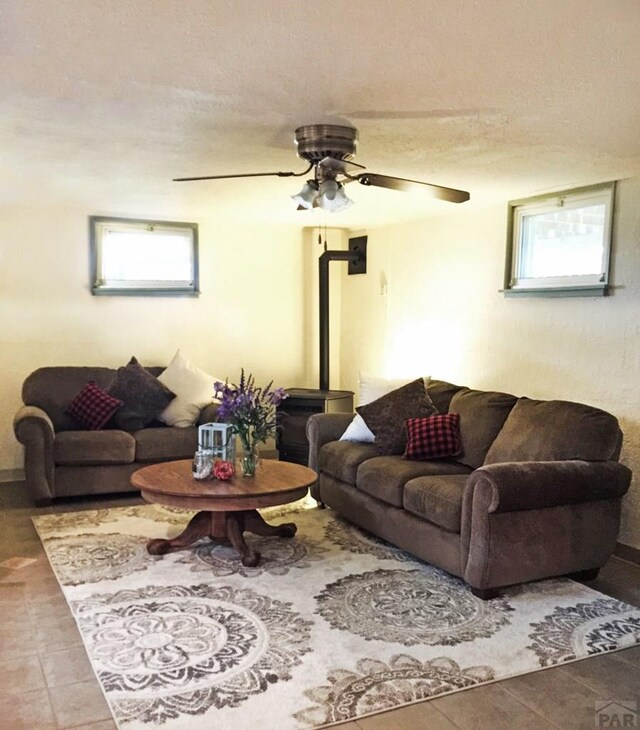 tiled living room with a ceiling fan and a textured ceiling