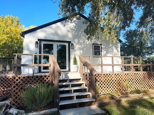 back of property featuring a wooden deck and stucco siding