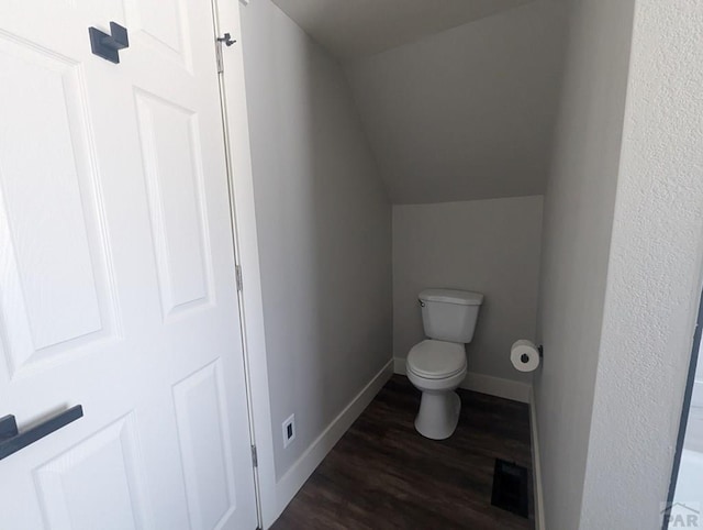 bathroom with toilet, wood finished floors, visible vents, baseboards, and vaulted ceiling