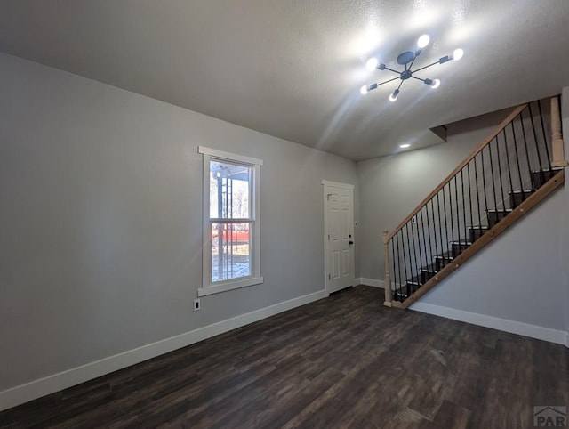 foyer with dark wood-style floors, stairs, and baseboards