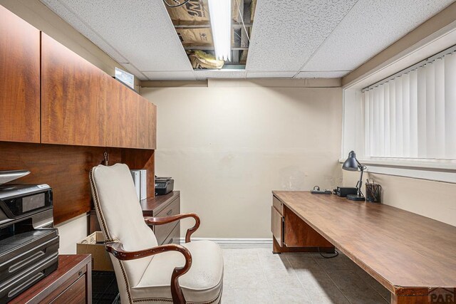 office space featuring a paneled ceiling and light tile patterned flooring