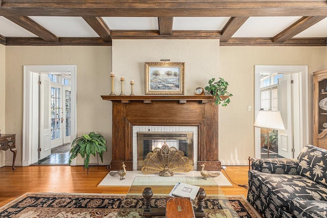 living room with a fireplace with flush hearth, coffered ceiling, beamed ceiling, and wood finished floors