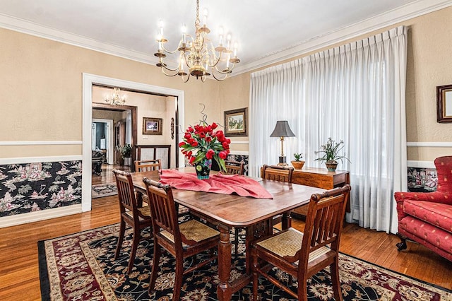 dining space featuring a chandelier, crown molding, and wood finished floors