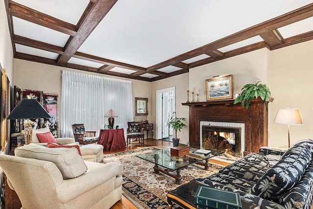 living room with beam ceiling, coffered ceiling, and wood finished floors