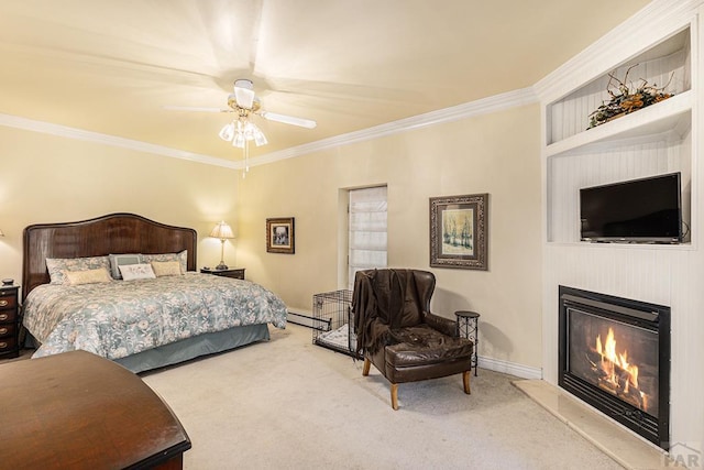 carpeted bedroom with crown molding, a fireplace, a baseboard heating unit, ceiling fan, and baseboards