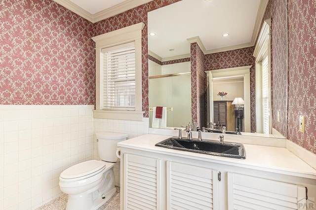 bathroom with a wainscoted wall, crown molding, tile walls, a stall shower, and wallpapered walls