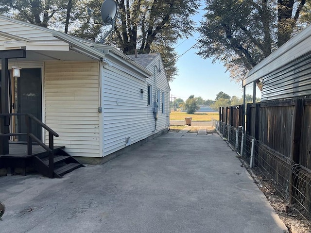 view of property exterior featuring fence and a patio