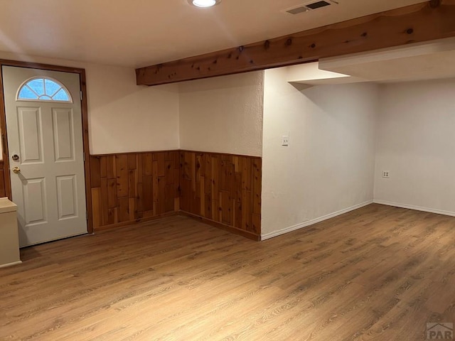 interior space featuring wooden walls, visible vents, wainscoting, wood finished floors, and beam ceiling