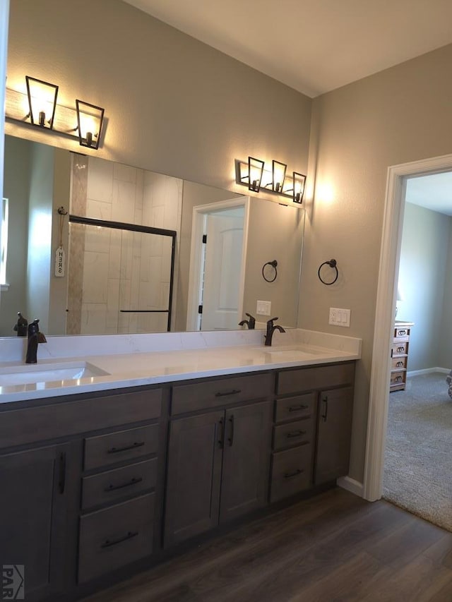 980 N Purcell Blvd, Pueblo West, CO 81007 - bathroom featuring a sink, baseboards, double vanity, and wood finished floors