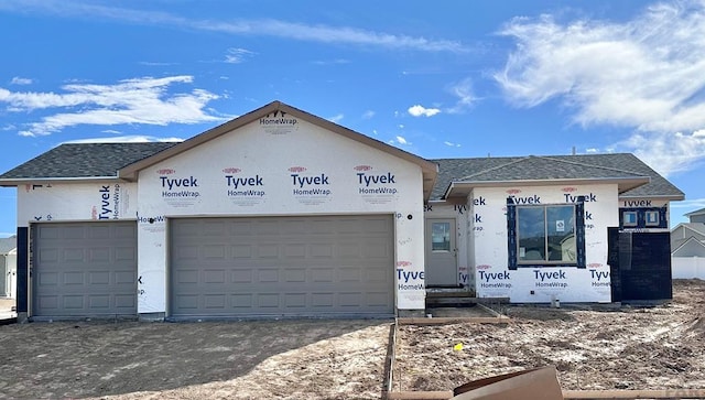 property in mid-construction with a garage and a shingled roof