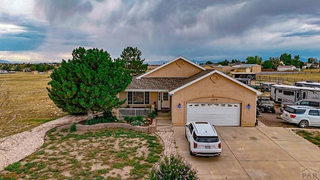 view of front of property featuring a garage, covered porch, driveway, and stucco siding