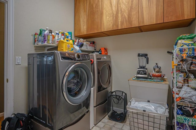 clothes washing area featuring cabinet space and independent washer and dryer