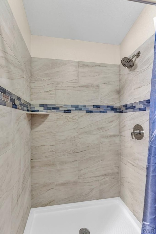 full bath with a tile shower