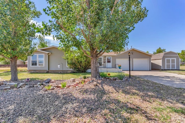 view of front of property with concrete driveway, an attached garage, and a storage shed