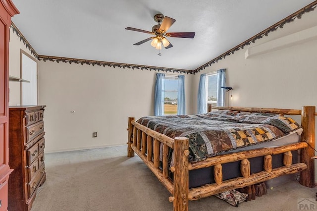 bedroom featuring ceiling fan, baseboards, and light colored carpet