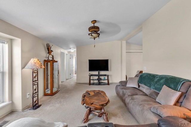 living area with baseboards, visible vents, and light colored carpet