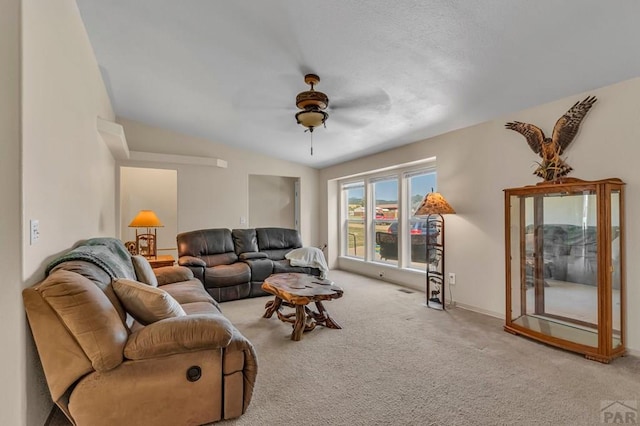 living room with vaulted ceiling, ceiling fan, and light colored carpet