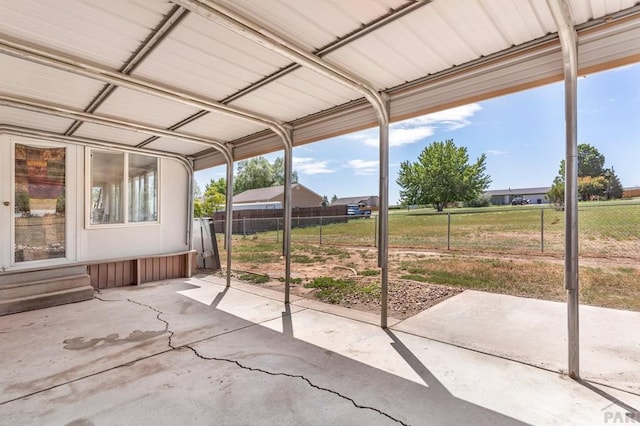 view of patio / terrace with entry steps, a carport, and fence