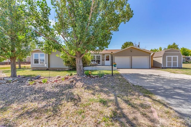 ranch-style home with a garage, an outdoor structure, driveway, a storage unit, and a front lawn