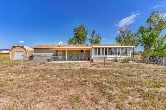 view of front of house with a front yard, fence, and an outbuilding