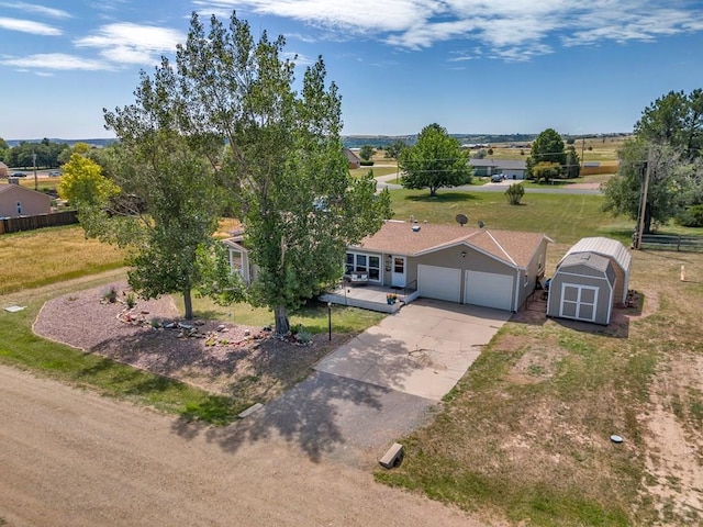 view of front of property featuring an outbuilding, a storage shed, a garage, fence, and driveway