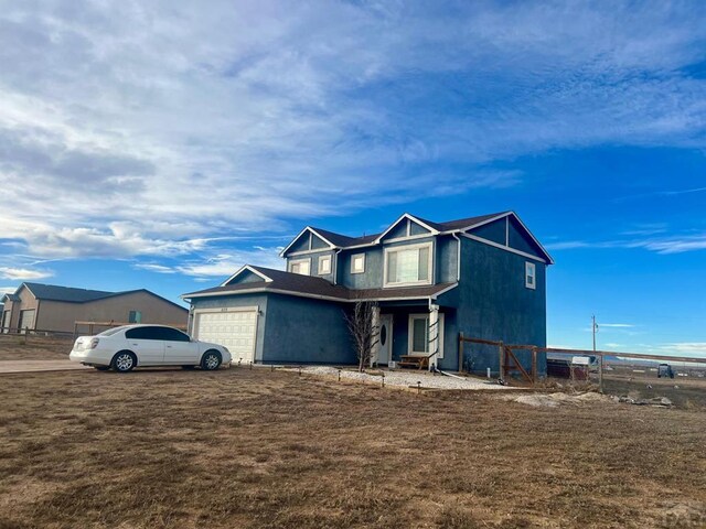 view of front of house featuring a garage, a front yard, and fence