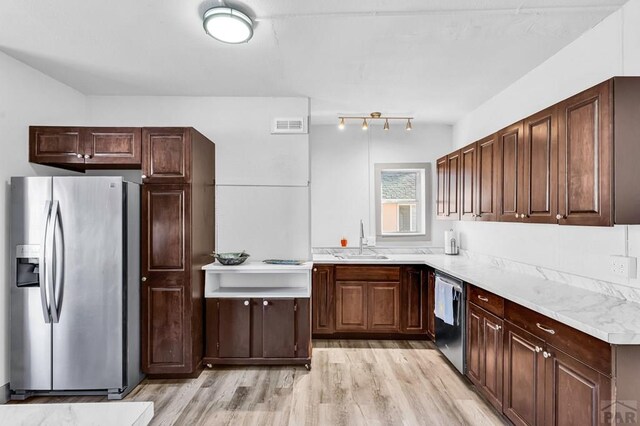 kitchen with stainless steel appliances, light countertops, visible vents, light wood-style flooring, and a sink