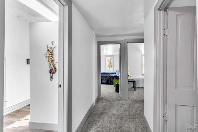 hallway with light carpet and baseboards