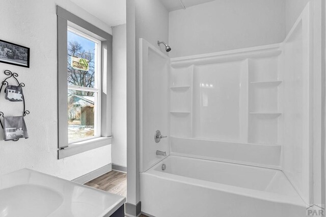 bathroom featuring  shower combination, baseboards, and wood finished floors