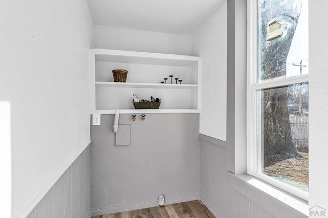 interior space featuring a wainscoted wall, laundry area, light wood finished floors, and washer hookup