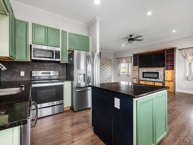 kitchen featuring stainless steel appliances, green cabinetry, and a center island