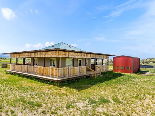 rear view of house featuring metal roof and a yard