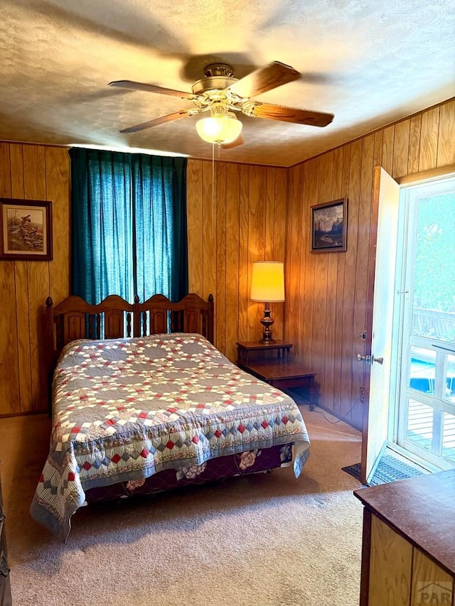602 Belleview Ave, La Junta, CO 81050 - carpeted bedroom featuring wooden walls, ceiling fan, and a textured ceiling