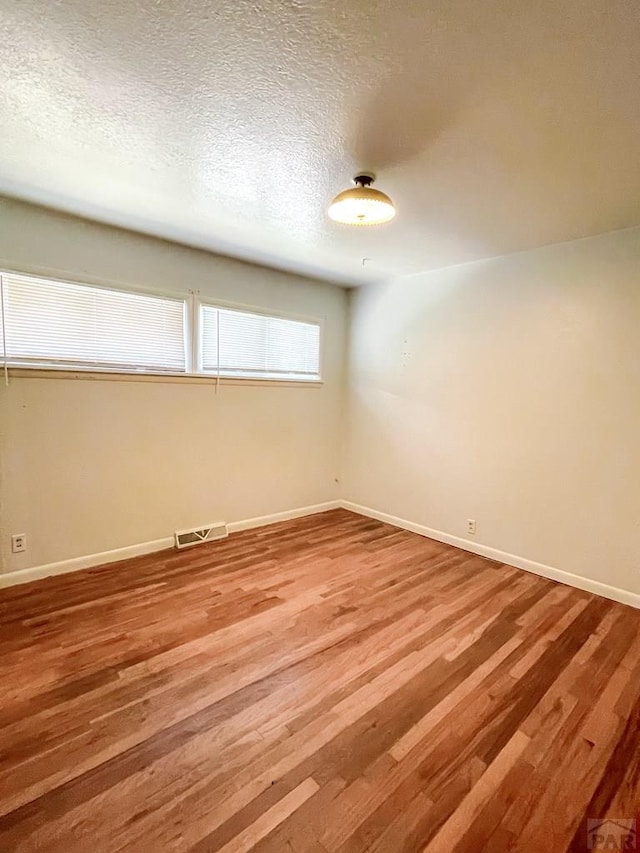 735 Poplar Ave, Las Animas, CO 81054 - unfurnished room featuring light wood finished floors and a textured ceiling