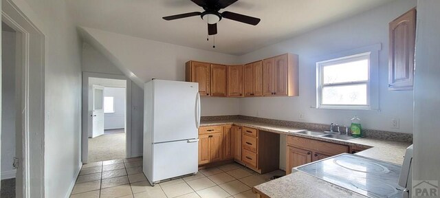 kitchen with ceiling fan, a sink, light countertops, range, and freestanding refrigerator