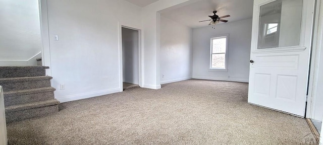 interior space with carpet floors, ceiling fan, stairway, and baseboards