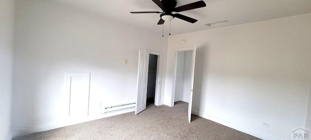 carpeted spare room featuring a baseboard heating unit, ceiling fan, visible vents, and baseboards