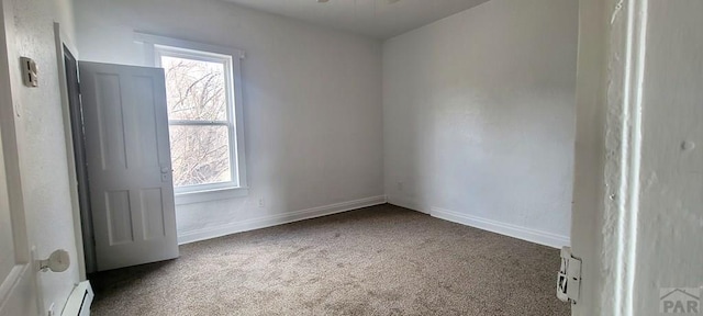 empty room featuring baseboard heating, dark carpet, a baseboard radiator, and baseboards