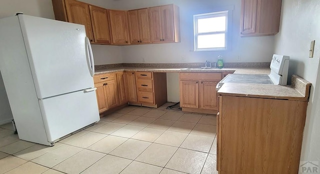 kitchen with white appliances, light countertops, a sink, and light tile patterned flooring