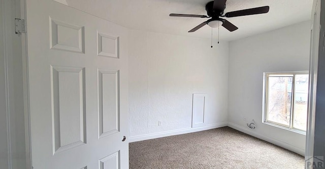 spare room with a ceiling fan, baseboards, and carpet flooring