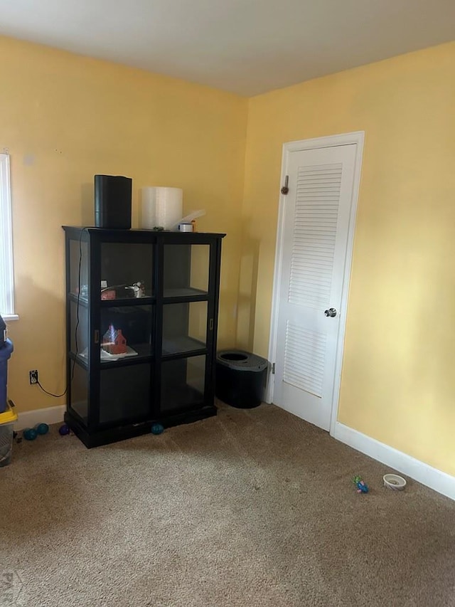 unfurnished room featuring baseboards and carpet