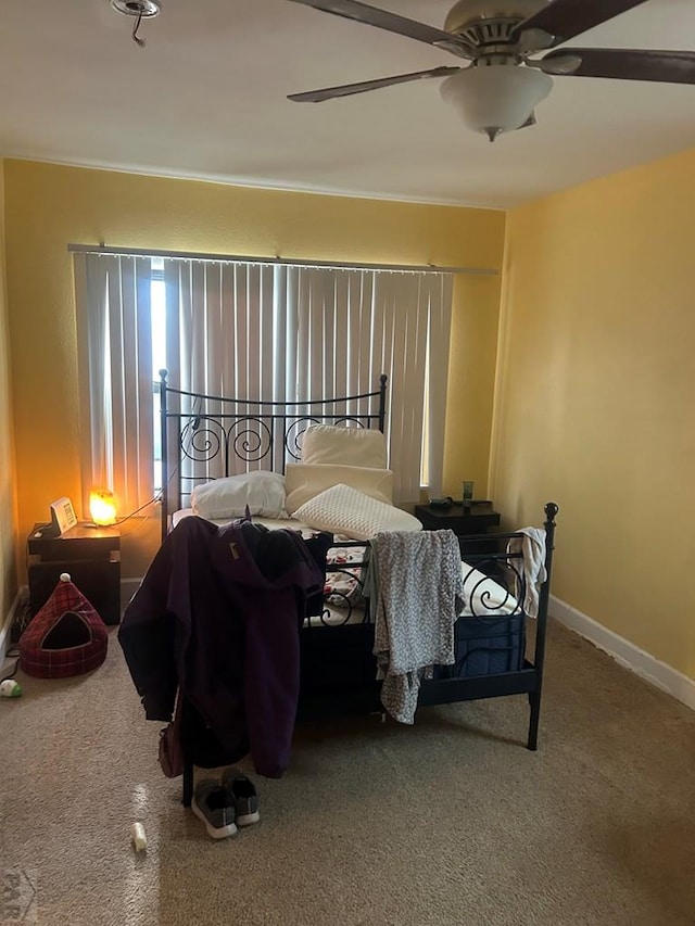 carpeted bedroom with baseboards and a ceiling fan