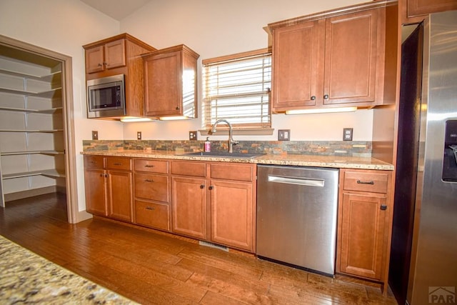 5707 Mark Twain Ln, Pueblo, CO 81008 - kitchen with appliances with stainless steel finishes, hardwood / wood-style floors, brown cabinetry, and light stone countertops