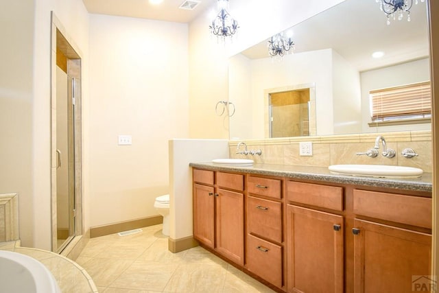5707 Mark Twain Ln, Pueblo, CO 81008 - bathroom with double vanity, a shower stall, a chandelier, a bathtub, and recessed lighting