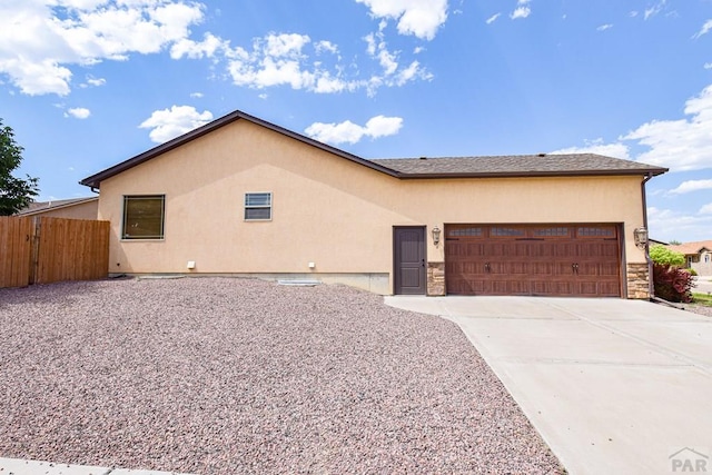 5707 Mark Twain Ln, Pueblo, CO 81008 - view of front of house with an attached garage, stucco siding, driveway, and stone siding