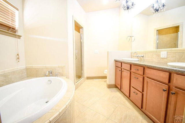 5707 Mark Twain Ln, Pueblo, CO 81008 - bathroom with double vanity, a garden tub, a shower stall, a chandelier, and tile patterned flooring