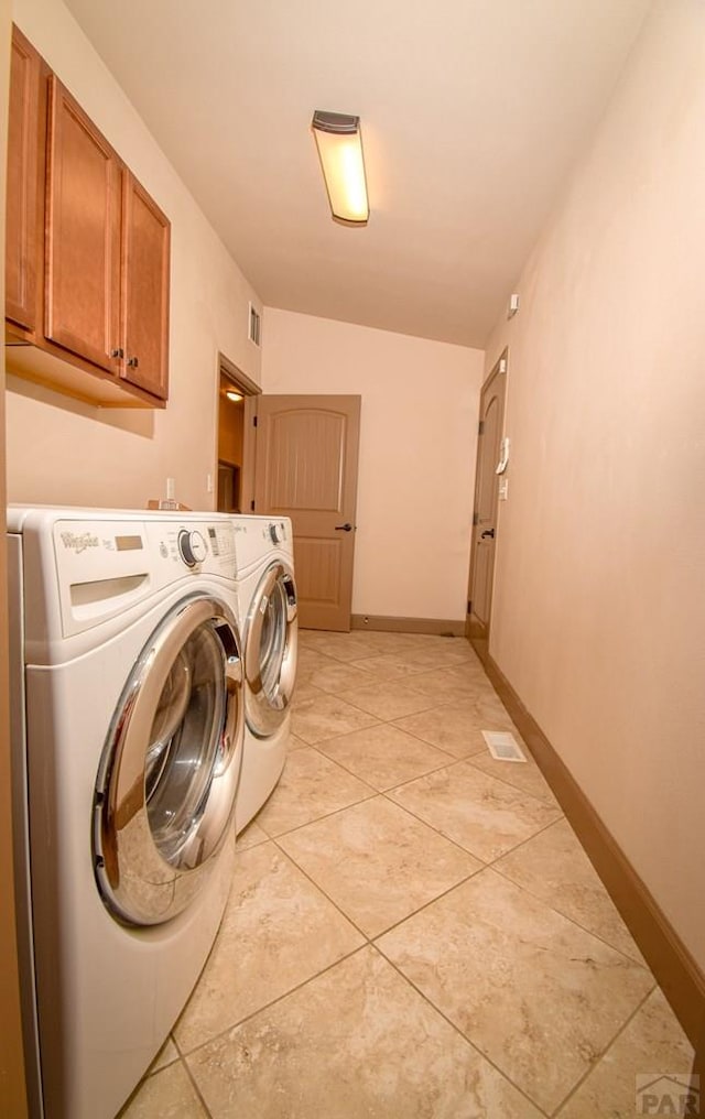 5707 Mark Twain Ln, Pueblo, CO 81008 - laundry area featuring washer and clothes dryer, cabinet space, and light tile patterned floors