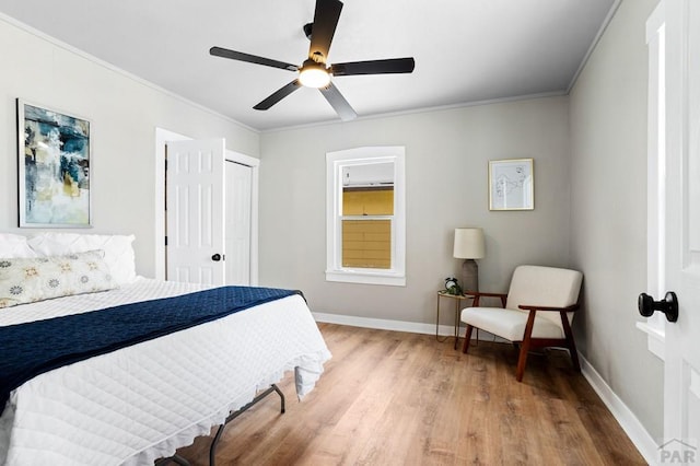 bedroom featuring ornamental molding, wood finished floors, and baseboards