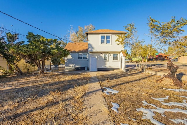 back of property featuring fence and stucco siding