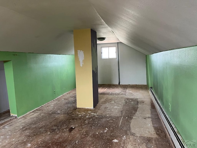 additional living space featuring a baseboard radiator and lofted ceiling